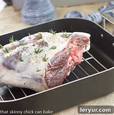 Glazed Leg of Lamb with Garlic and Rosemary nestled in a roasting pan.