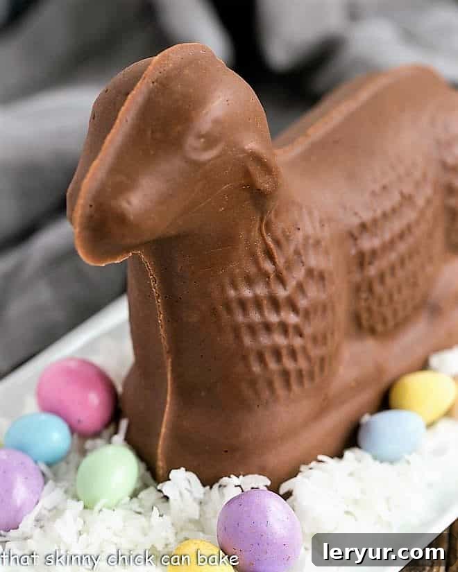 Fudge lamb on a bed of coconut with candy eggs on a white tray