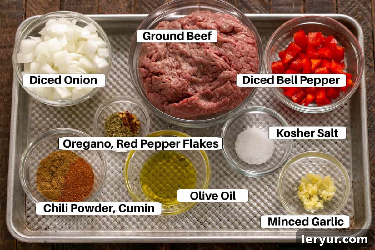 Homemade Soft Shell Beef Tacos 2 A vibrant display of fresh ingredients for Soft Shell Tacos, including ground beef, diced onions, garlic, bell peppers, and various spices, arranged neatly on a sheet pan.