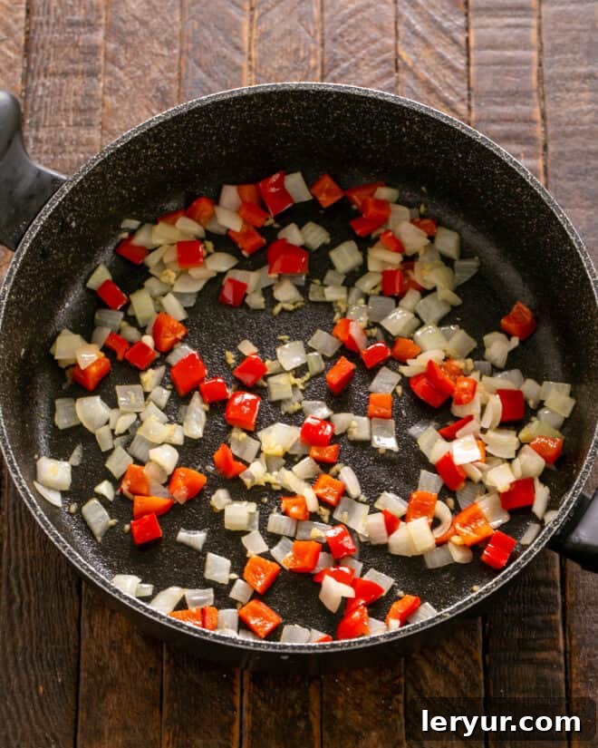 Homemade Soft Shell Beef Tacos 3 Step 1: Sautéing diced onions, minced garlic, and bell peppers in olive oil until softened for homemade soft shell tacos.