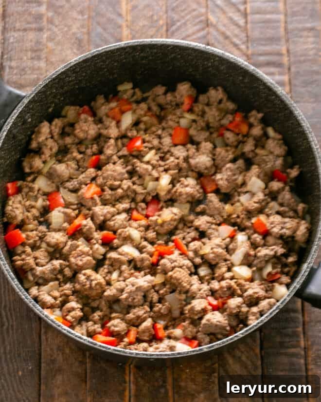Homemade Soft Shell Beef Tacos 4 Step 2: Adding ground beef to the skillet with sautéed vegetables, breaking it apart and cooking until thoroughly browned.