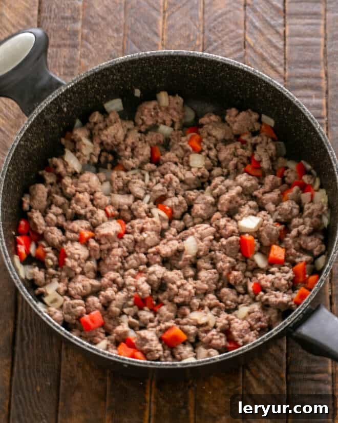 Homemade Soft Shell Beef Tacos 5 Step 3: Stirring in the homemade taco seasonings—chili powder, cumin, oregano, and red pepper flakes—into the browned ground beef mixture.