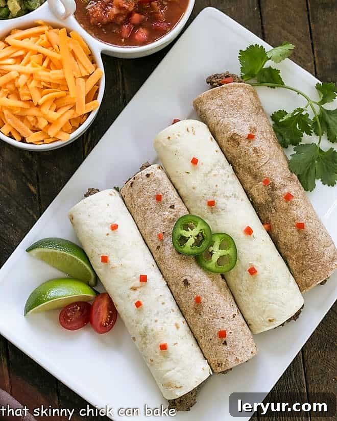 Soft Shell Tacos Recipe - An easy, homemade beef taco recipe that only takes a few more minutes than adding a packet of taco seasoning, offering superior taste and health benefits! A close-up, overhead shot of four perfectly assembled soft shell beef tacos on a white platter, garnished with vibrant peppers and fresh cilantro.