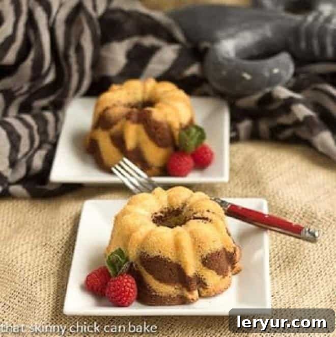 Two Mini Zebra Bundt Cakes on square white dessert plates, ready to be enjoyed.