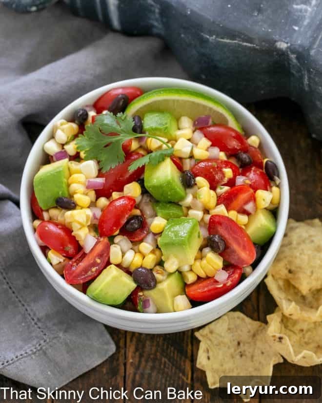 Vibrant Black Bean Avocado Corn Salsa 3 Overhead view ob black bean and corn salsa in a white serving dish with tortilla chips