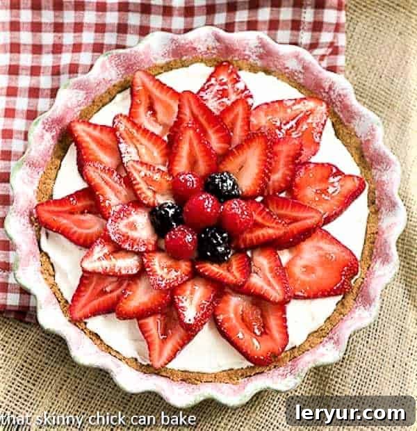 Strawberry Cream Cheese Dessert in a ceramic pie plate, showcasing its layers and fresh berry topping.