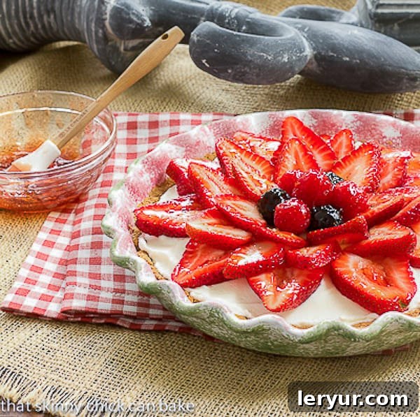 Strawberry Cream Cheese Dessert being glazed with red currant jelly.