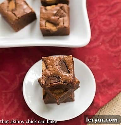 Irresistible Fudgy Brownies with Reese's Chunks Stacked Fudgy Brownies with Reese's Chunks on a white plate, showcasing their rich texture