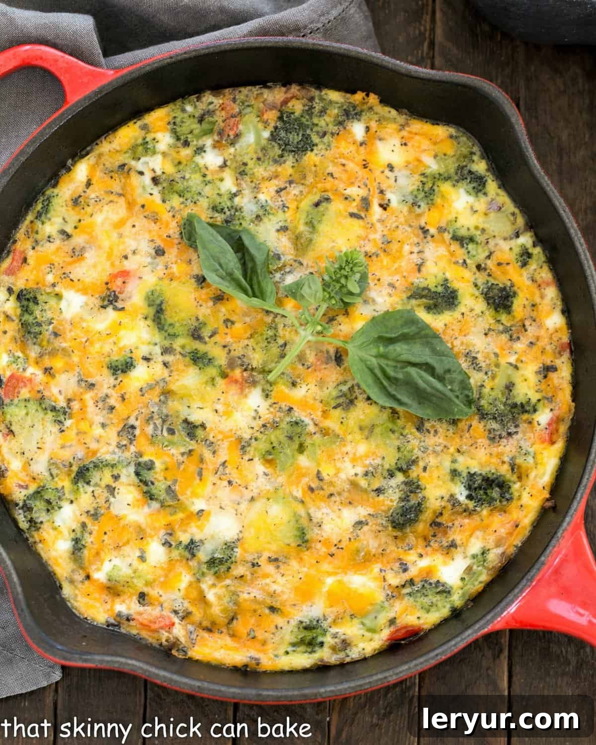 Overhead view of roasted broccoli frittata in a red cast iron pan, ready to be served.