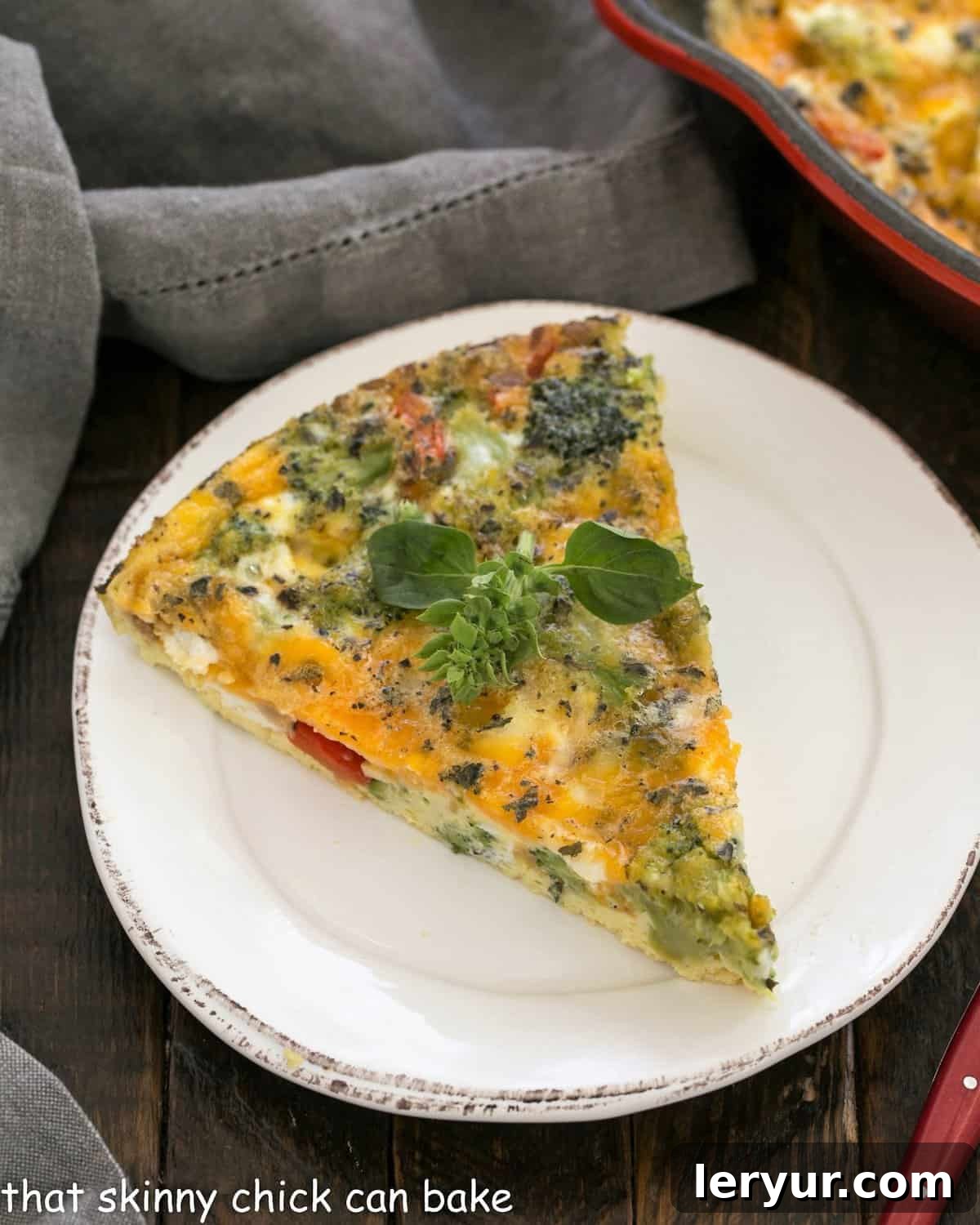 Overhead view of a perfectly cooked slice of roasted broccoli frittata on a round white ceramic plate, ready to be enjoyed.