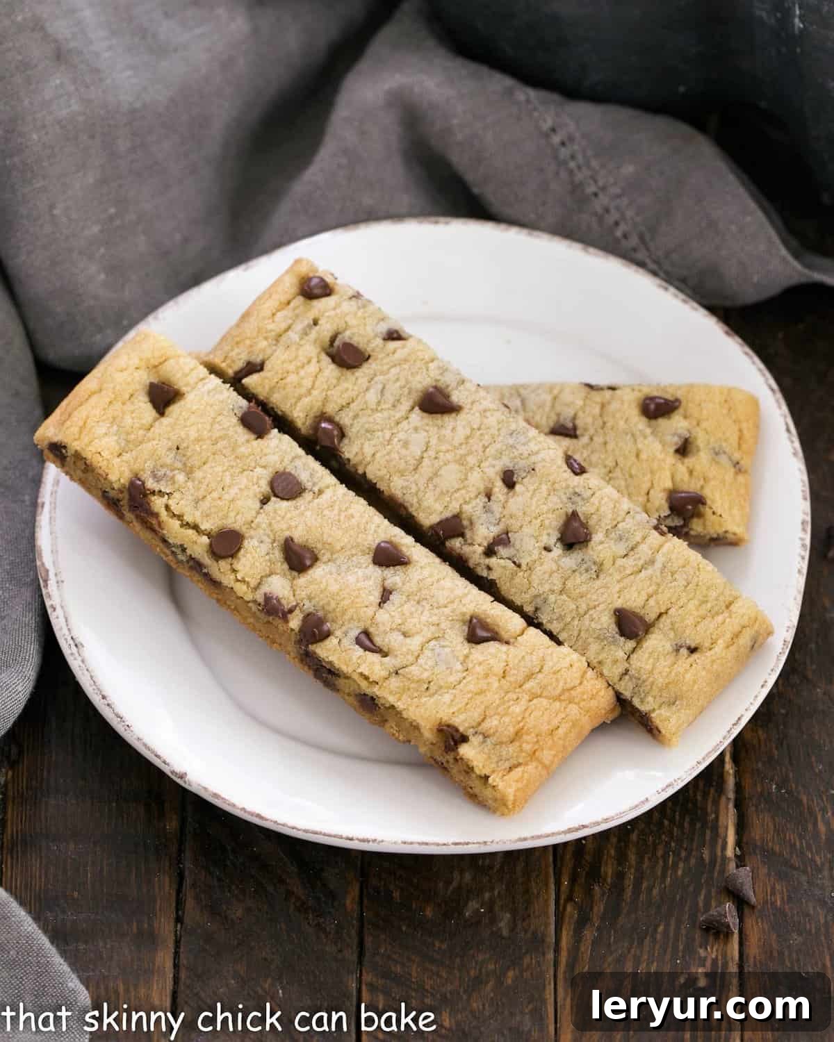 Several chocolate chip cookie dippers elegantly arranged on a small, round white ceramic plate, ready for dipping.
