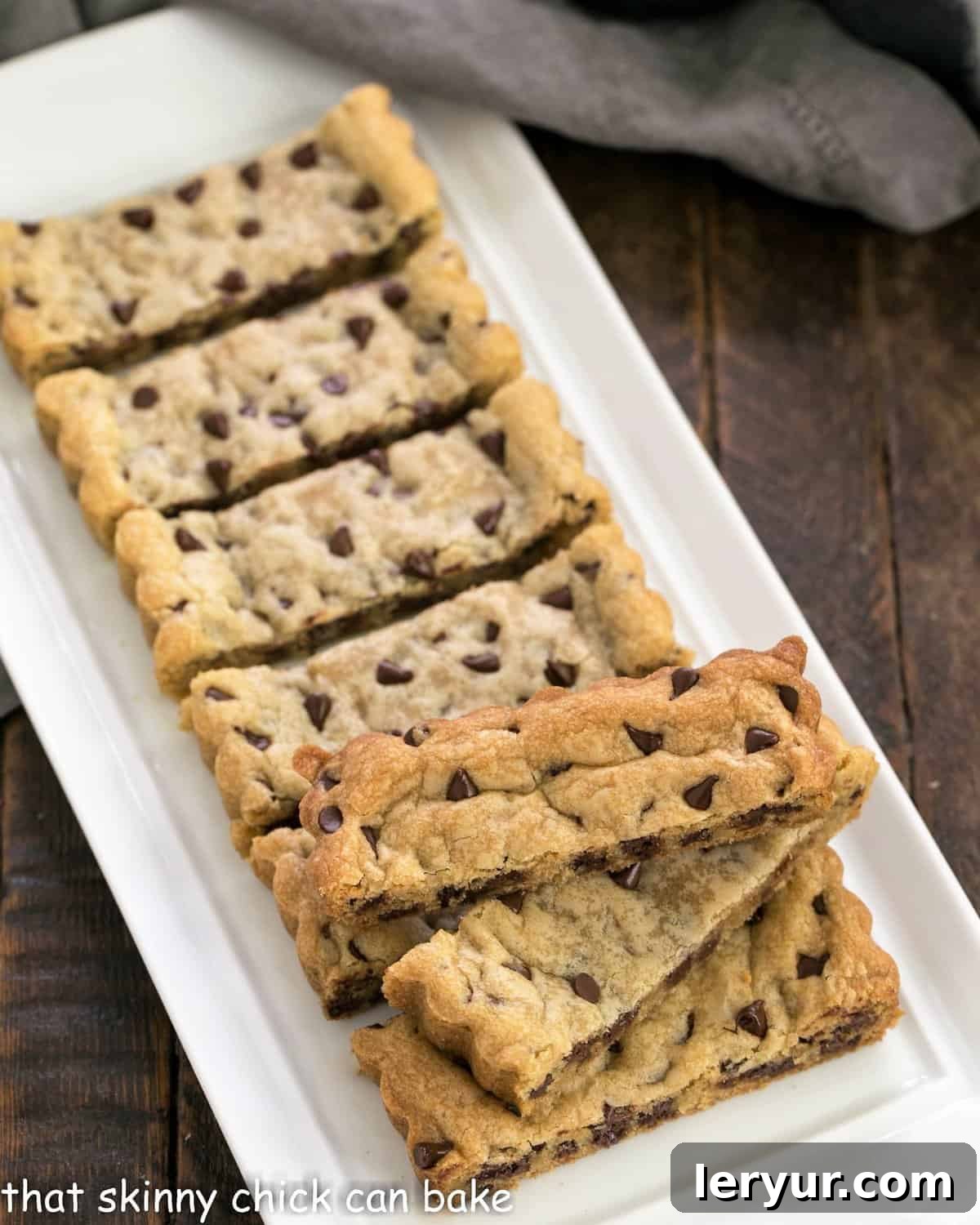 A tray filled with golden-brown chocolate chip cookie bars, freshly baked and ready to be cut into sticks.