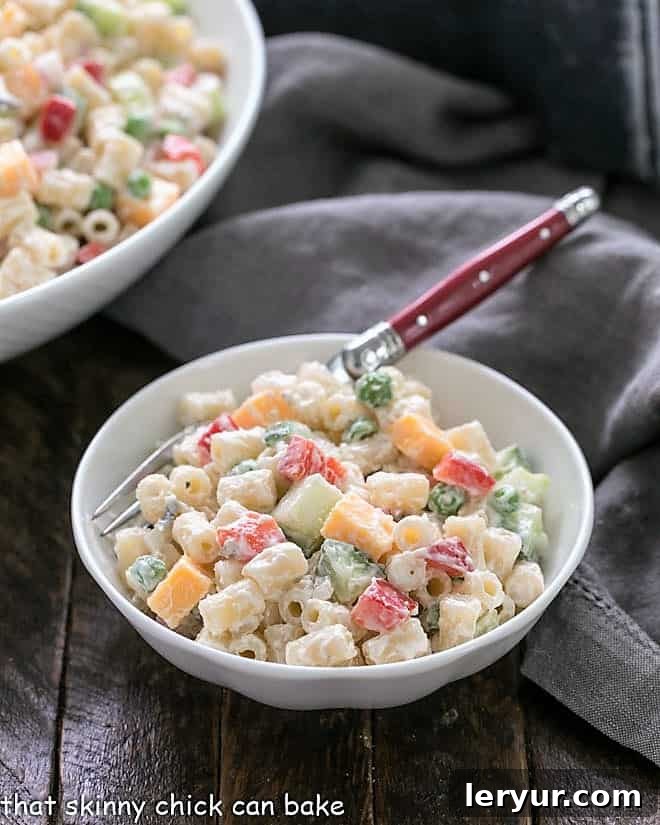 Easy Pasta Salad with a yogurt dressing - perfect for a summer barbeque and easily adapted with your favorite ingredients Easy pasta salad recipe in a small white bowl with a red handled fork, ready to be enjoyed.