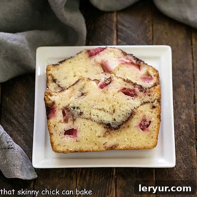 Two slices of moist Cinnamon Swirl Rhubarb Bread on a square white plate, showing the beautiful cinnamon ribbon.