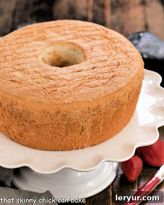 How to Make Angel Food Cake from Scratch! Achieve a perfect light and fluffy texture, far superior to any boxed mix or grocery store version. A beautifully baked whole angel food cake, perfectly golden brown, sitting on an elegant white cake stand.