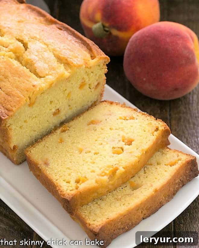 Experience the taste of summer with this Glazed Peach Pound Cake - a sweet, dense loaf cake filled with succulent diced peaches and drizzled with a fresh, homemade peach glaze! A beautifully presented sliced peach pound cake rests on an elegant white ceramic serving tray, ready to be enjoyed.