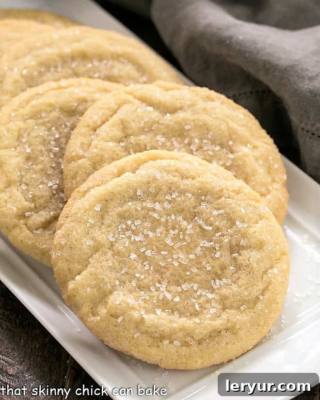 These Giant Sugar Cookies are soft, chewy with a coating of crunchy coarse sugar! You won't think you'll eat the whole thing, but you will! Staggered sugar cookies on a white tray.