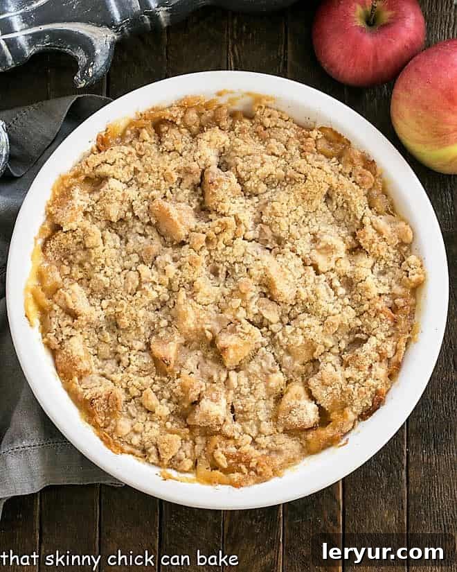 Golden Apple Crumble Served with Velvety Custard 4 Overhead view of apple crumble in a white ceramic pie plate.