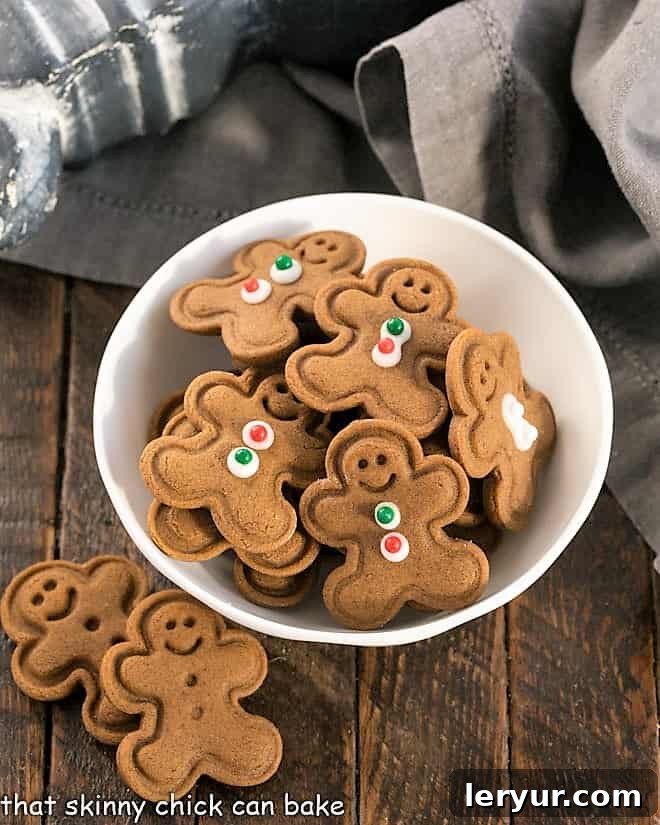 A small white bowl filled with charming mini gingerbread men cookies, each adorned with simple icing details, ready to be enjoyed.