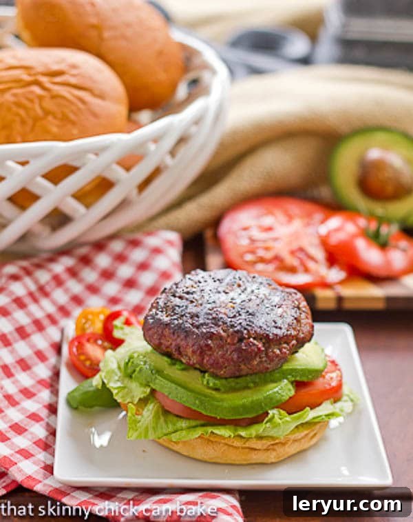 A close-up of a California Burger on a white plate, resting on a red and white checked napkin.