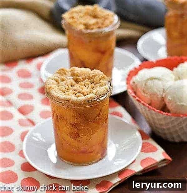 Delightful Peach Crisp in Jars with a side of creamy vanilla ice cream, perfect for summer.