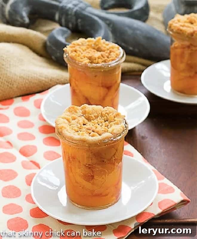 Close-up of individual Peach Crisp in Jars, showcasing the golden crumb topping and juicy peach filling.