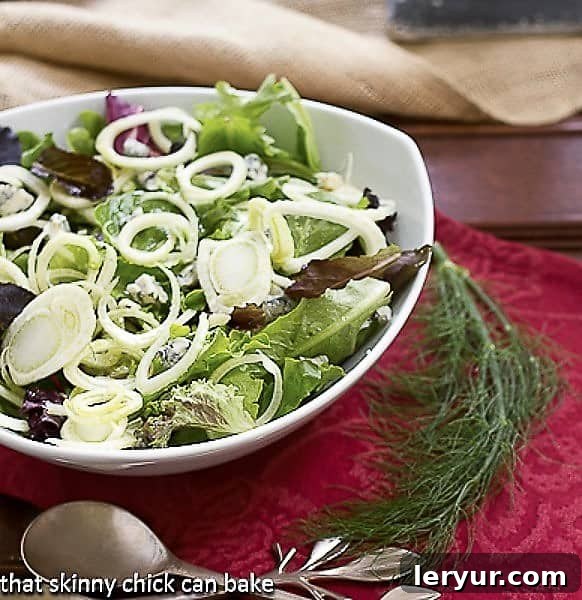 Fennel and Gorgonzola Salad in a elegant white serving bowl, garnished with a delicate fennel frond, ready to be enjoyed