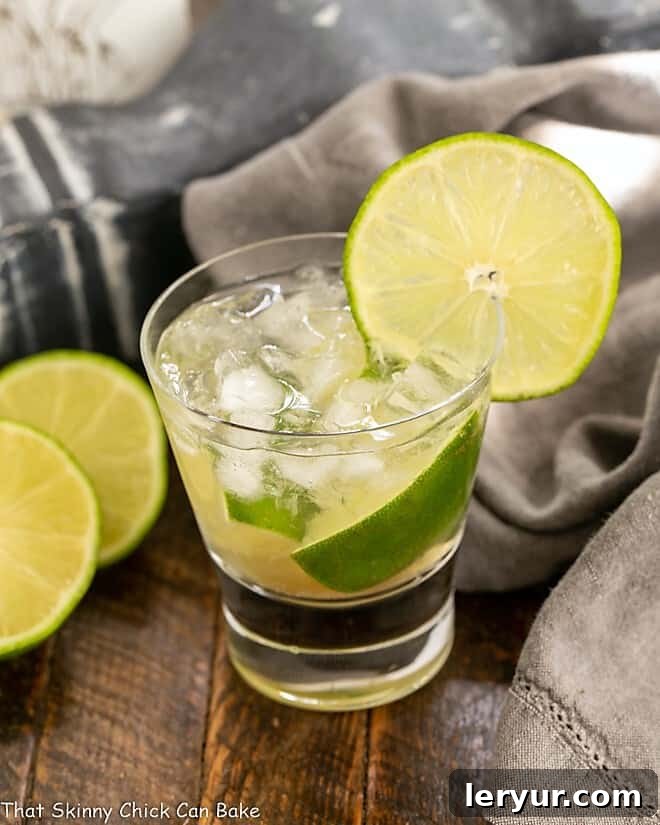 Brazilian Caipirinha Cocktail - Lime, raw sugar and Brazilian rum marry in this exotic cocktail! Caipirinha Cocktail in a highball glass with a lime garnish.