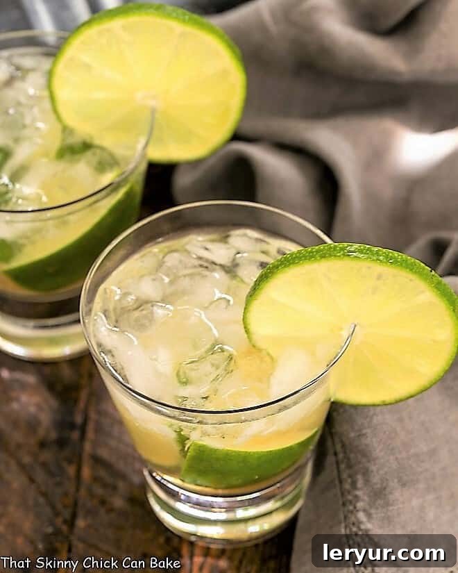 Brazilian Caipirinha Cocktail - Lime, raw sugar and Brazilian rum marry in this exotic cocktail! Two Brazilian Caipirinha Cocktail in highball glasses.