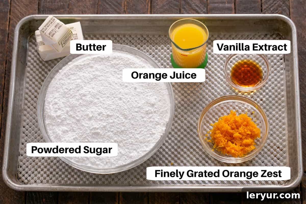 The vibrant ingredients for the orange roll filling and frosting, including powdered sugar, softened butter, fresh orange zest, orange juice, and vanilla extract, are neatly arranged on a sheet pan.