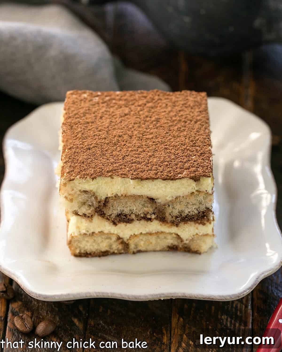 Decadent Tiramisu From Scratch 6 A slice of tiramisu on a square white plate.