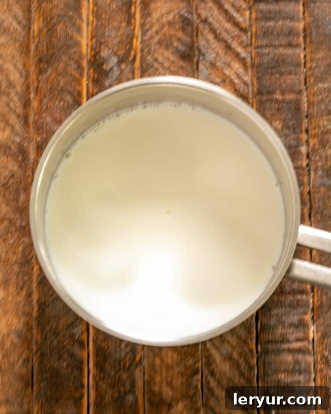 Decadent Italian Chocolate Budino 5 Milk and cream gently simmering in a saucepan on the stove.