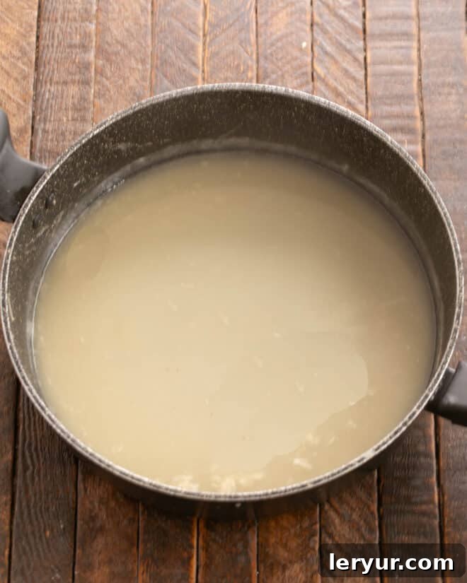 Creamy Homestyle Turkey Tetrazzini 4 A rich, creamy white sauce being prepared in a skillet, whisked to perfection.