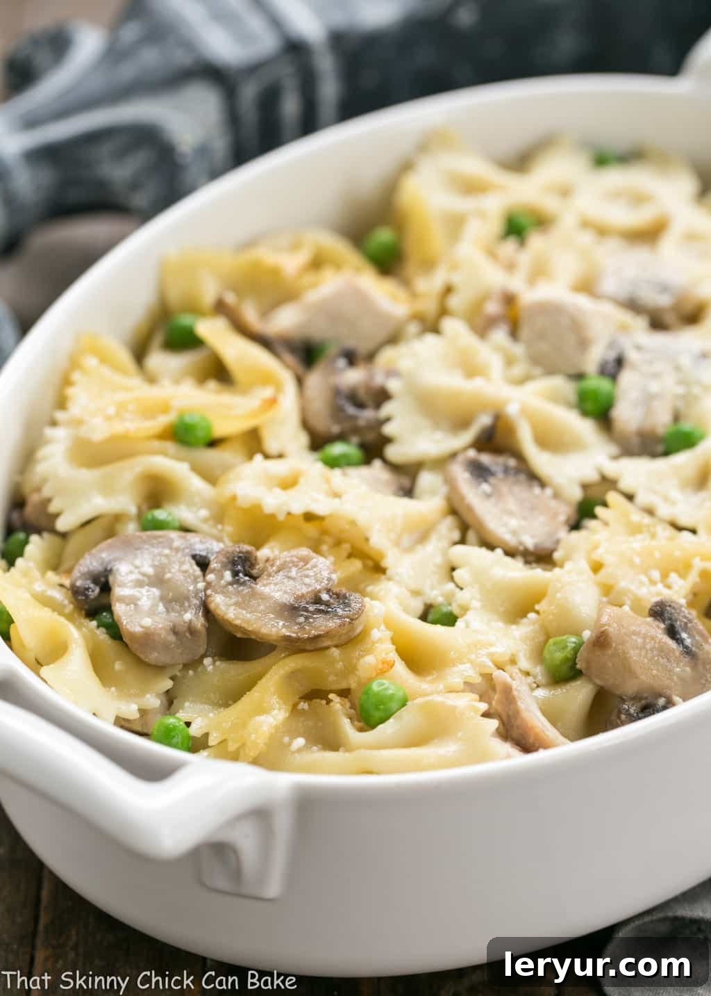 The Best Turkey Leftover Recipes - An ultimate comfort food, this turkey casserole features savory poultry, sweet peas, earthy mushrooms, and a dreamy cream sauce. A truly perfect post-Thanksgiving recipe! Close-up shot of a golden-brown Turkey Tetrazzini casserole in an oval dish, showcasing its rich, creamy texture and bubbly top.