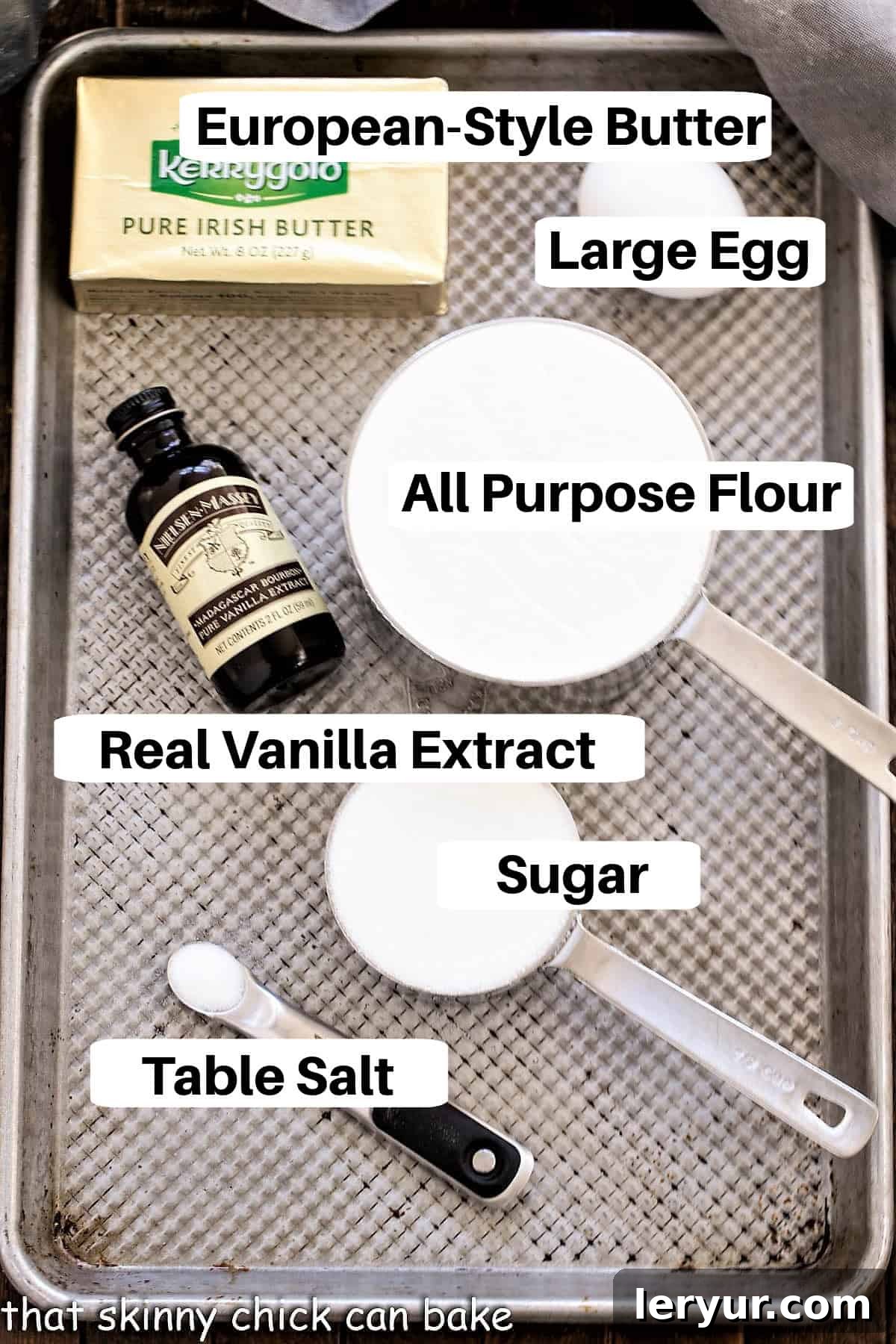 An array of fresh Danish butter cookie ingredients laid out on a baking sheet, each clearly labeled for easy identification.