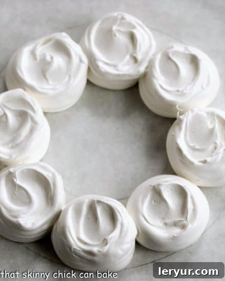 Jolly Pavlova Crown 5 Undecorated pavlova wreath shell on a parchment lined baking sheet, showing the piped meringue mounds.