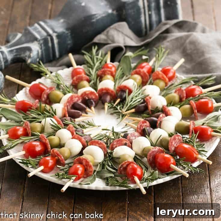Appetizer skewers arranged in a wreath pattern on a serving plate with fresh herbs