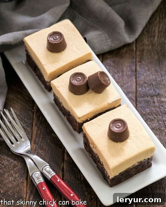 Rows of freshly baked Fudgy Caramel Brownies, generously topped with creamy caramel buttercream and adorned with Rolo candies, arranged on a rustic wooden tray.