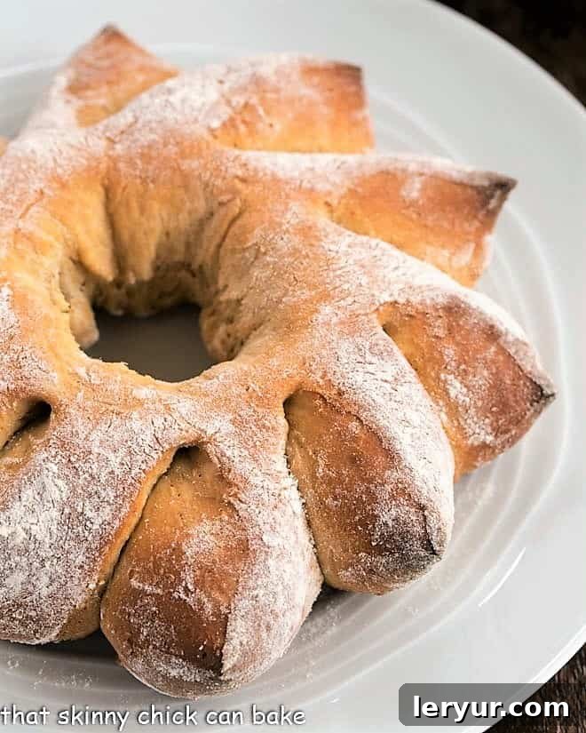 Golden brown Honey Whole Wheat Bread Wreath on a white serving plate, ready to be enjoyed.