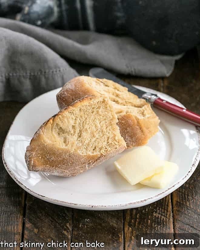 Two perfectly golden slices of Honey Whole Wheat Bread Wreath on a small white plate, invitingly arranged.
