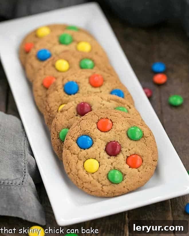 Classic M & M Cookies lined up neatly on a white rectangular tray, ready to be enjoyed.