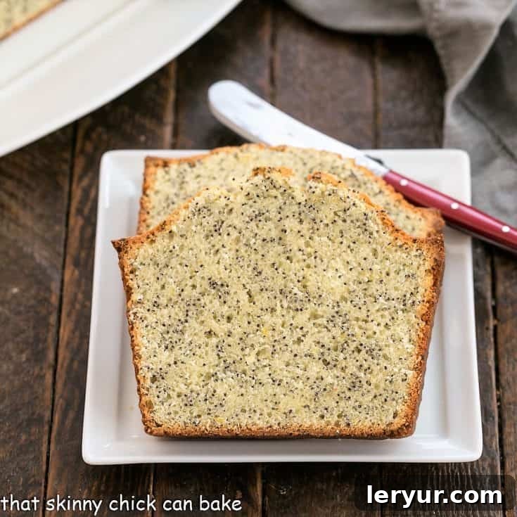 2 slices of lemon poppy seed bread on a square white plate with a red handle knife