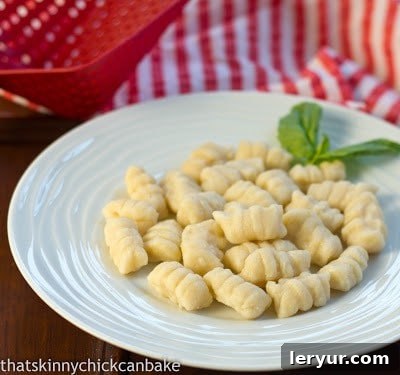 Pillowy Ricotta Gnocchi in Tangy Marinara 2 Ricotta Gnocchi without sauce on a white plate, showcasing their soft, delicate texture before being dressed.