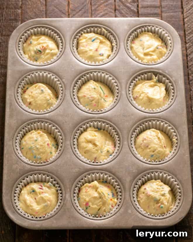 Funfetti batter in a muffin tin.
